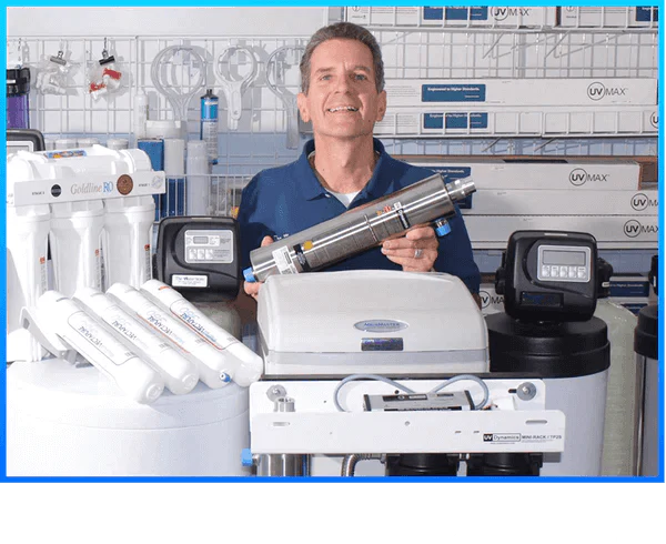Man holding a cylindrical product in a workshop setting with various equipment and tools.